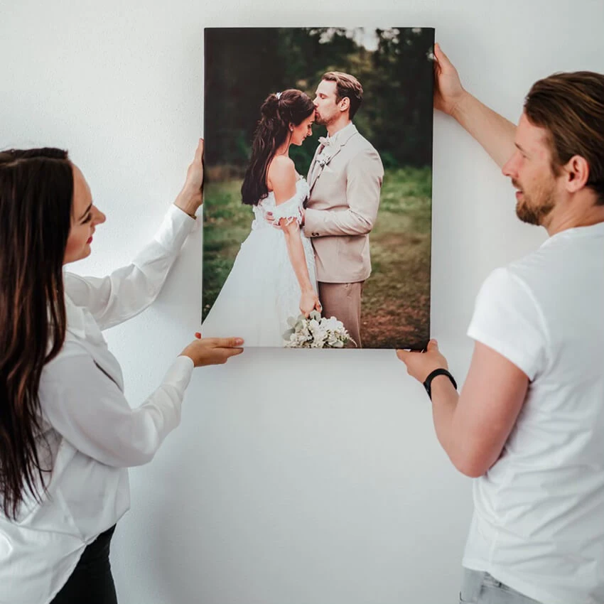 Ein Paar hängt sein Hochzeitsfoto auf Leinwand auf
